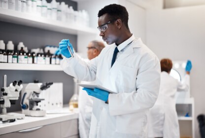 Science, research and black man test tube and tablet for medical analysis and innovation in laboratory. Pharmaceutical analytics, medicine study and scientist in South Africa checking vaccine results