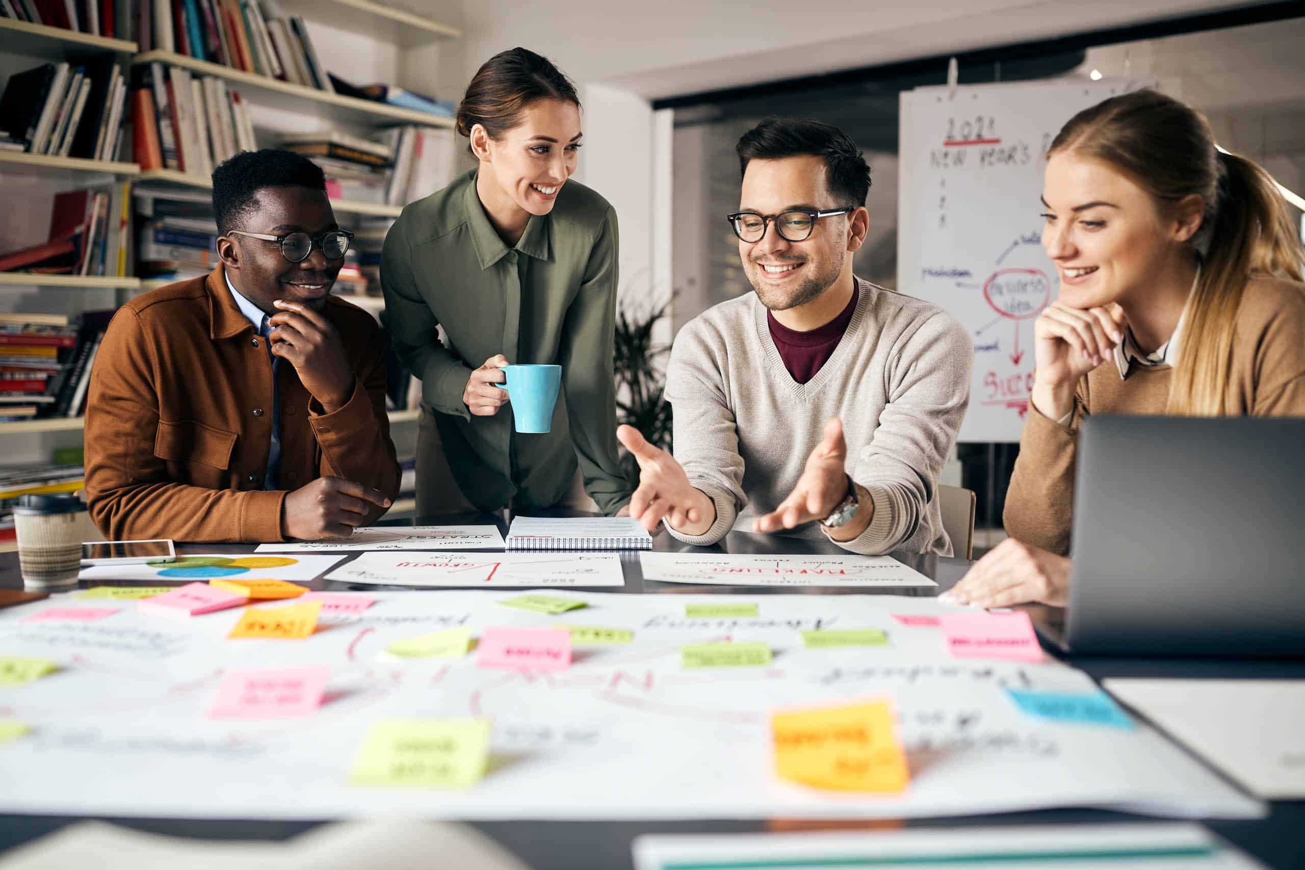 A group of tech consultants sitting around a table with sticky notes.