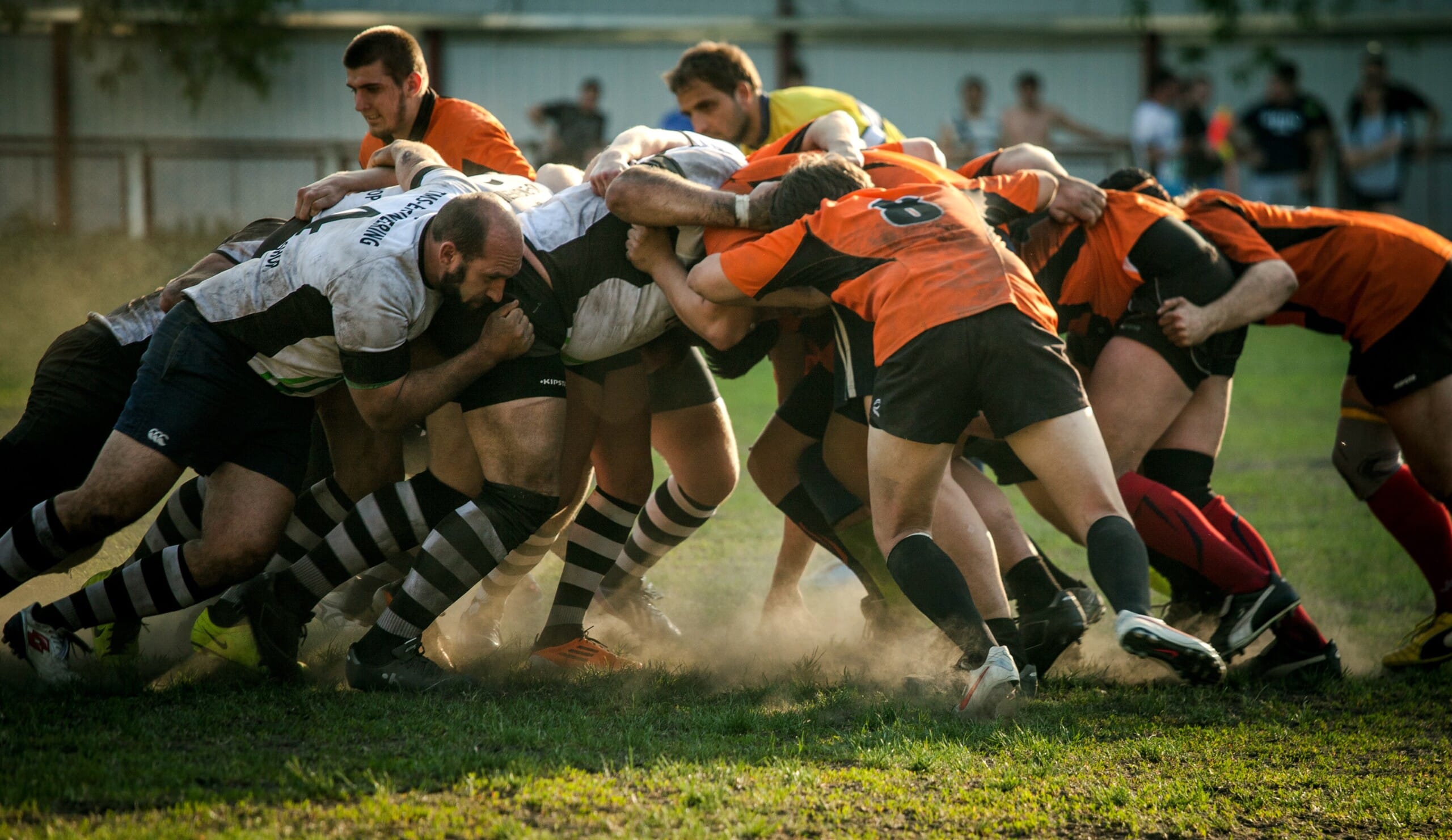 A group of rugby players are fighting for the ball, showcasing their strength and agility on the field.