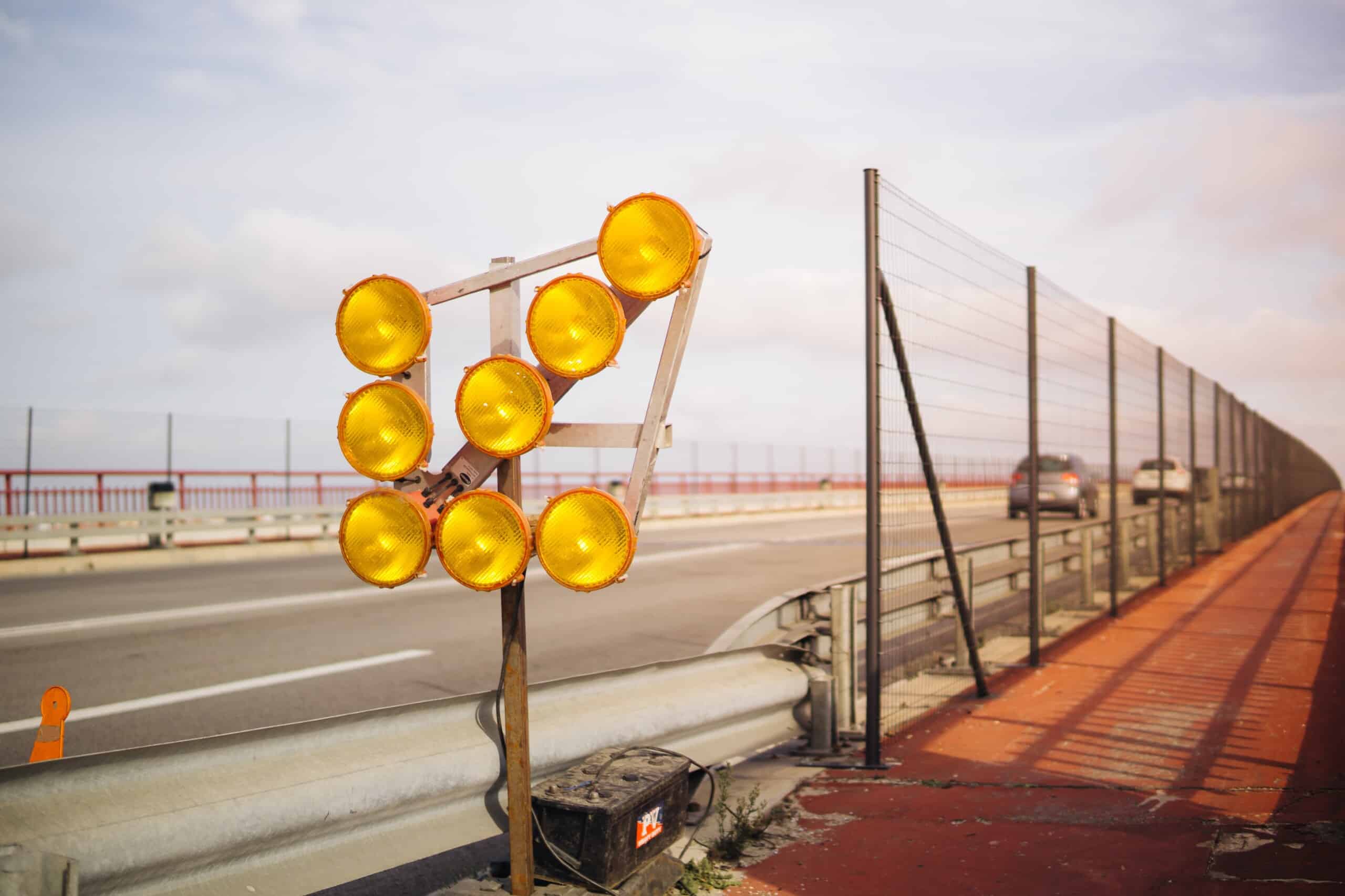 A global company has installed yellow traffic lights on the side of a road.