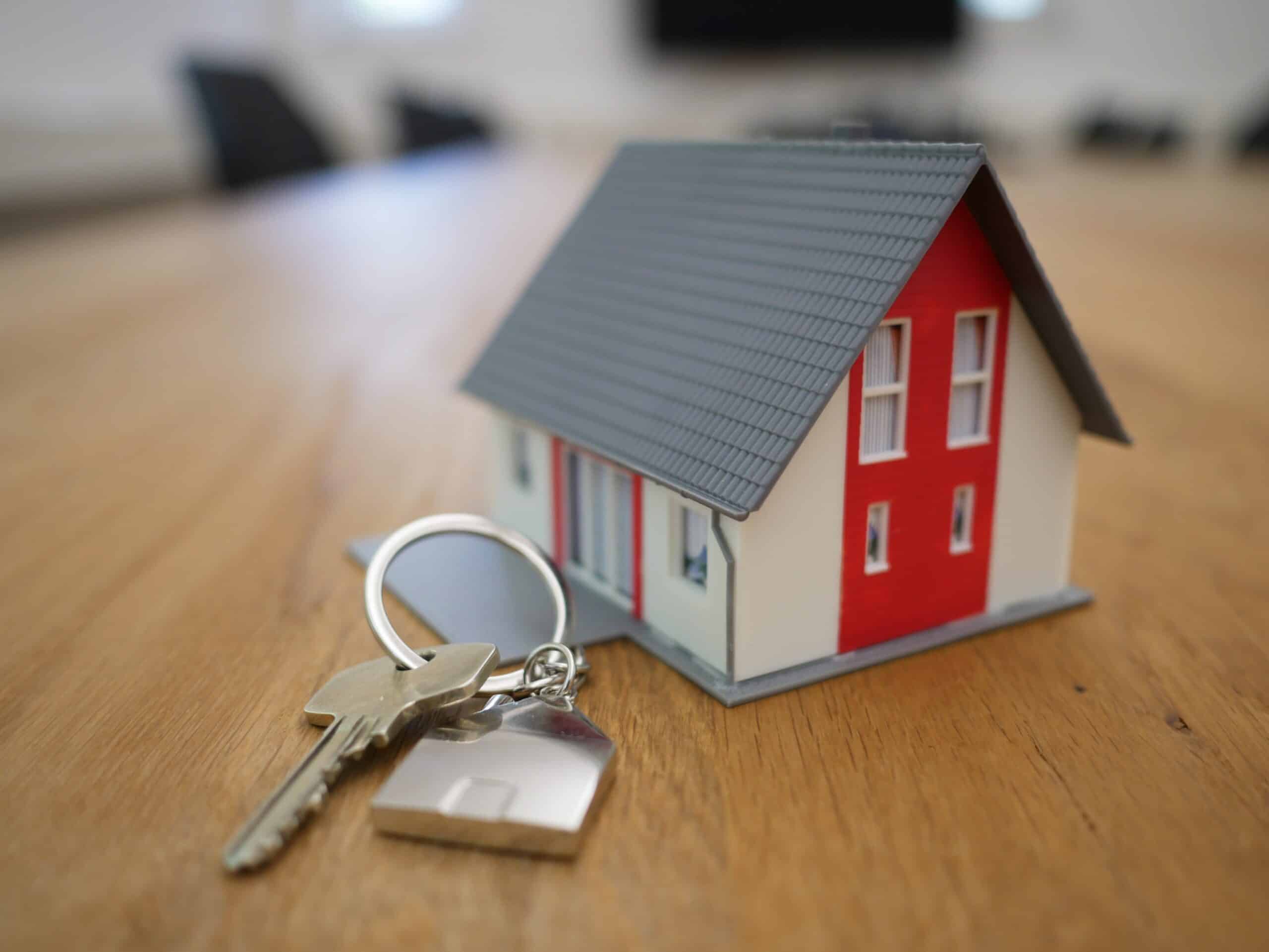 A tech model of a house with keys on a table.