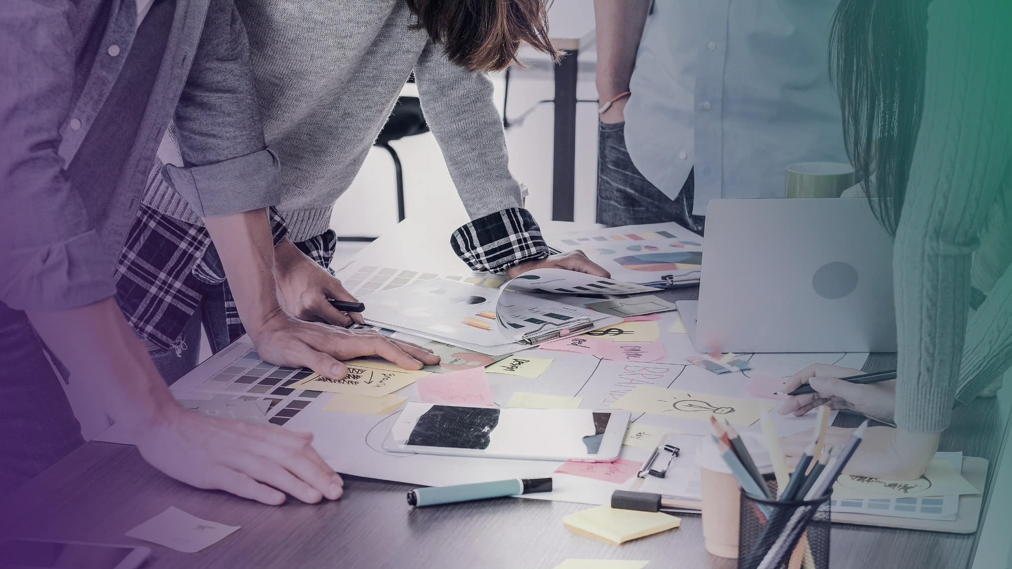 A global team of tech experts collaborating around a table in a company.