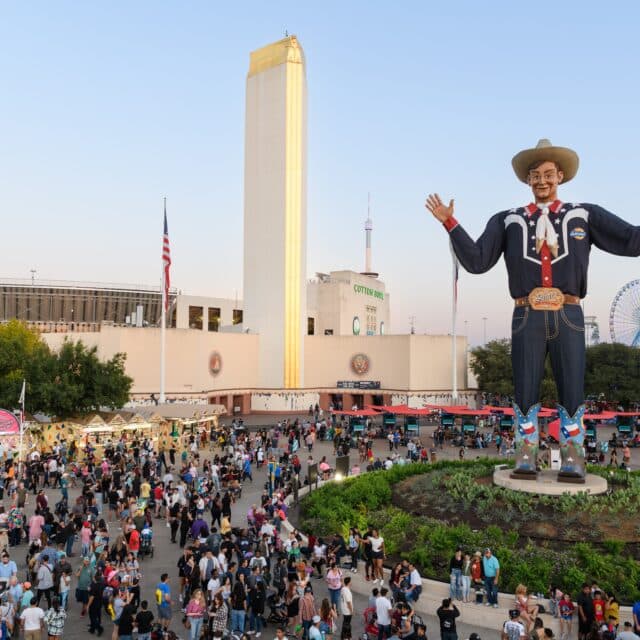 An innovative statue of a cowboy strategically placed amidst a crowd of people.