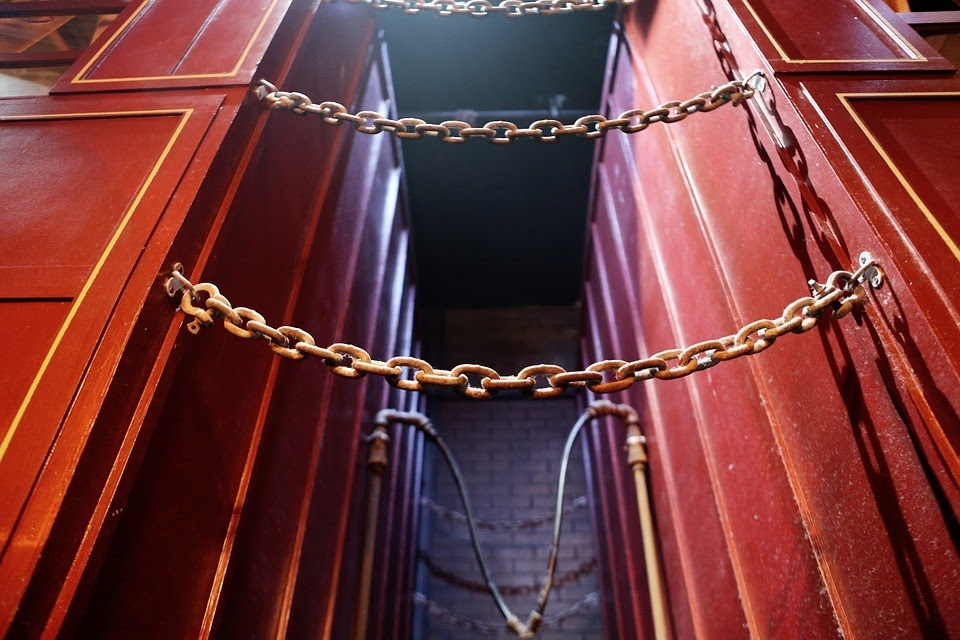 A global door colored red with chains attached to it.