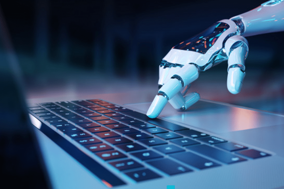 A strategic robot is typing on a laptop keyboard.