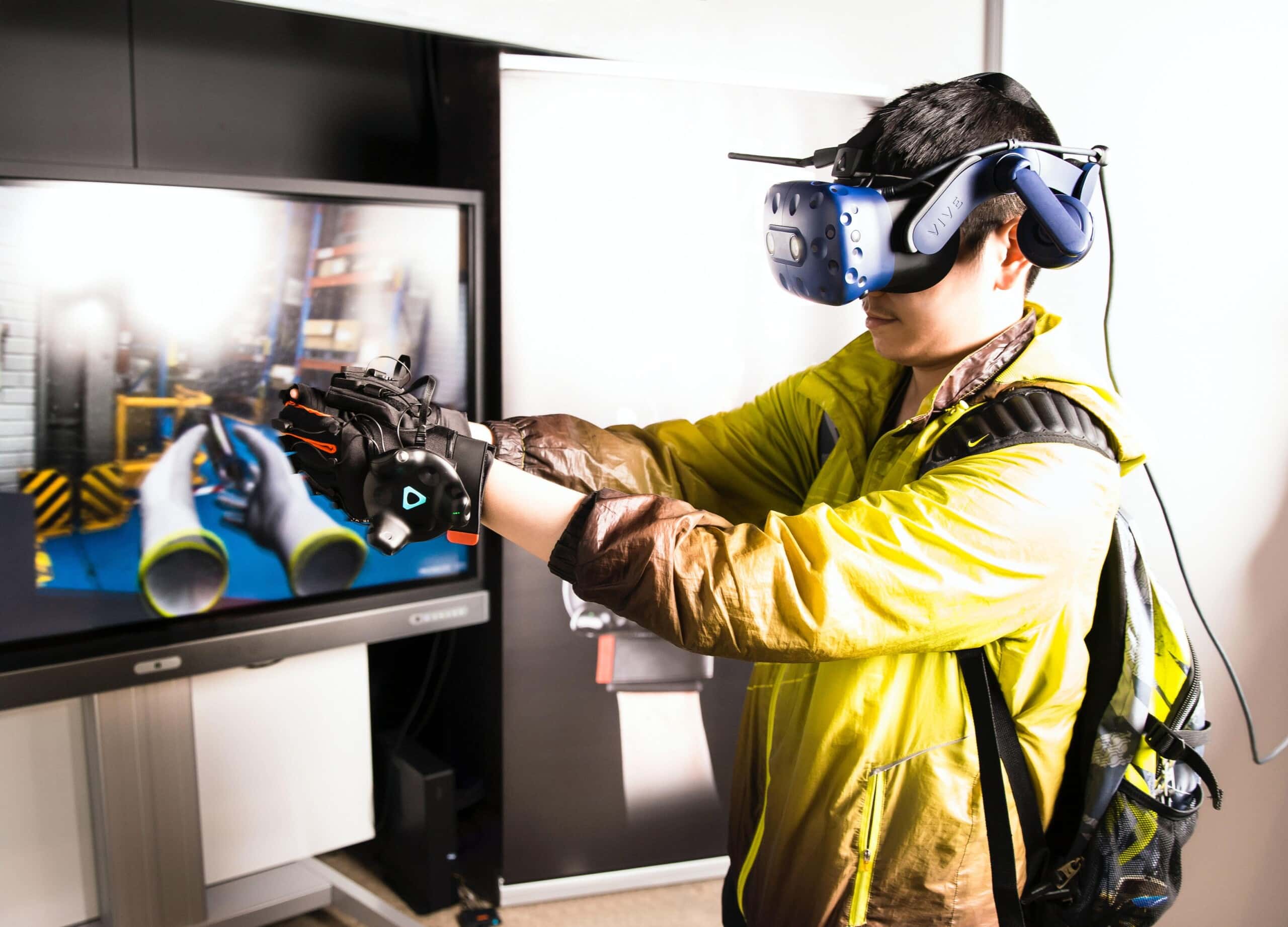 An innovative man wearing a virtual reality headset playing a game on a tv.