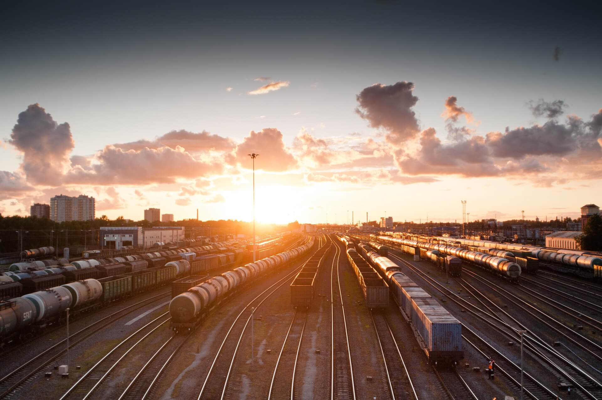 A strategically positioned train on a train track captures the beauty of a global sunset.