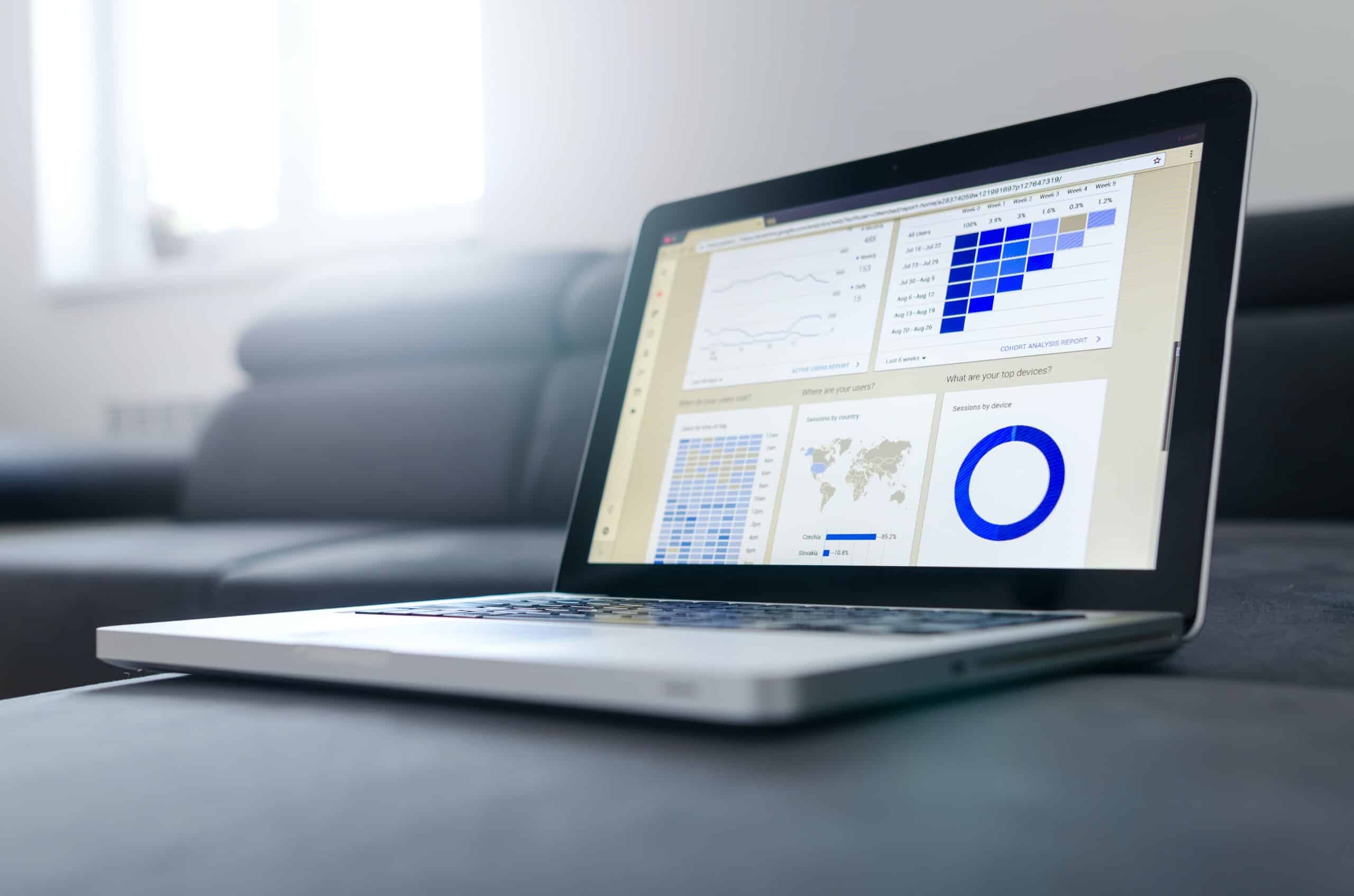 A strategic consulting company's laptop displaying graphs while placed on a couch.