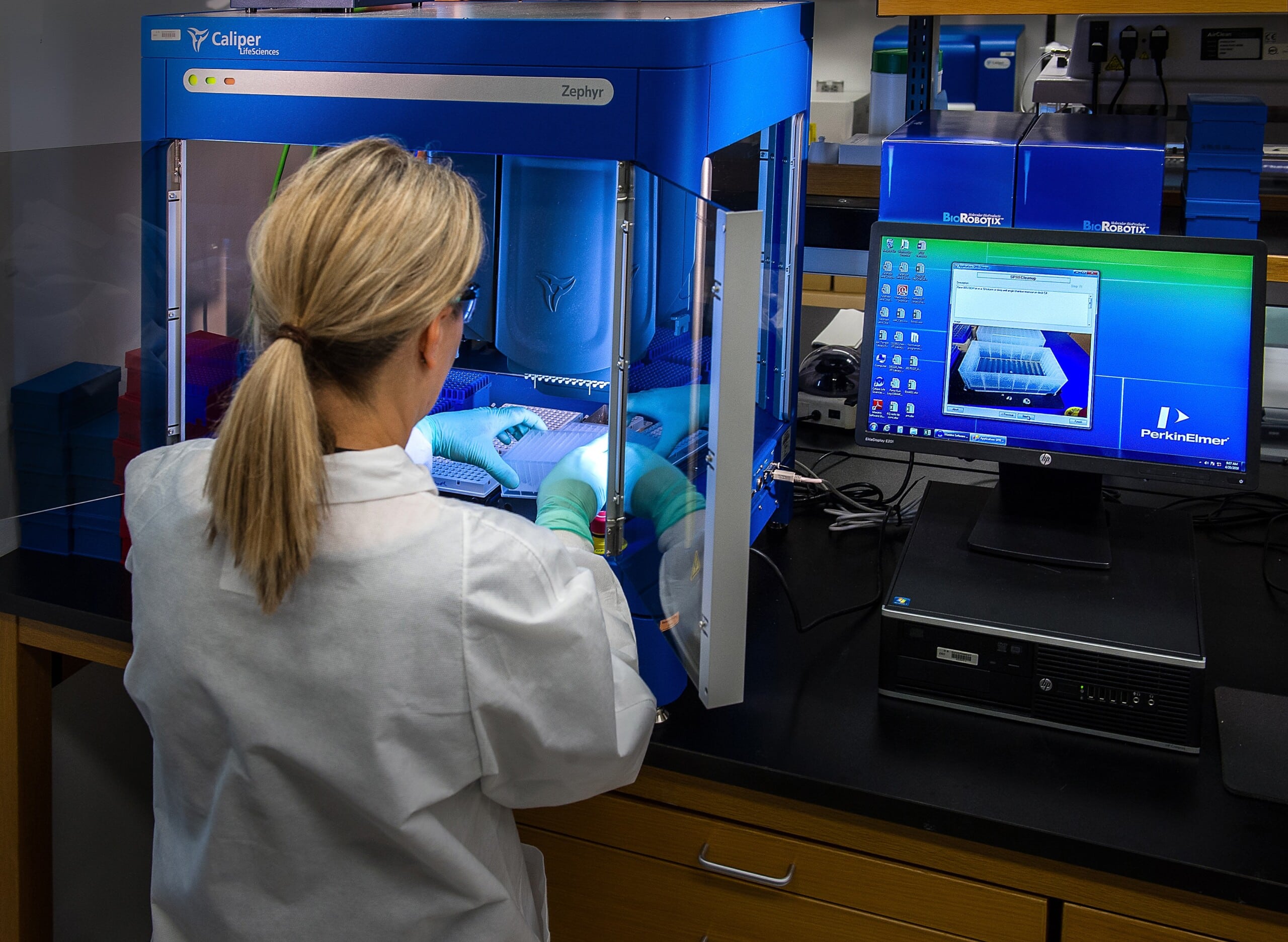 A woman in a tech lab looking at a blue machine.