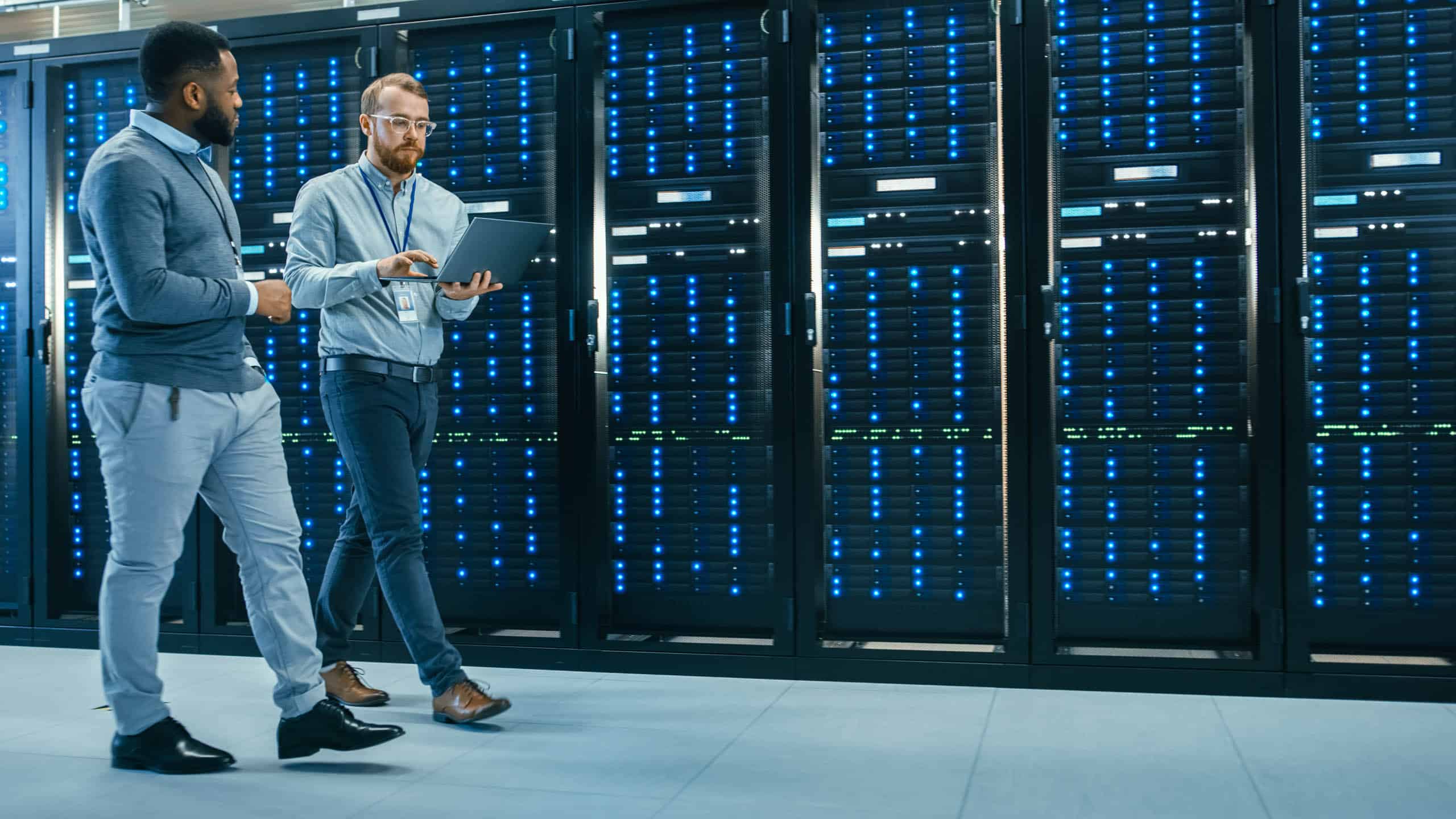 Two men strategically innovate in a global server room.