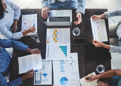 A group of consulting professionals sitting around a table.