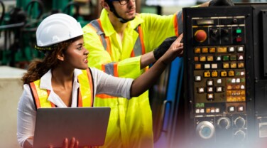 female Mechanical Engineer Works on Personal Computer and worker mehcanic man working at Metal lathe industrial manufacturing factory. Professional Engineer team Operating lathe Machinery
