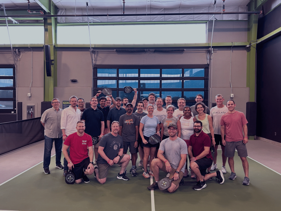 A group of people posing for a picture on a tennis court, capturing memorable moments.