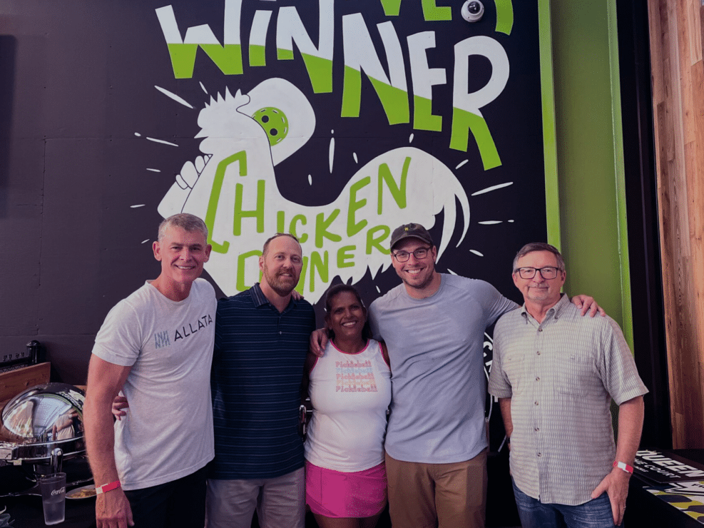 A group of people posing for a photo in front of a sign showcasing their careers.